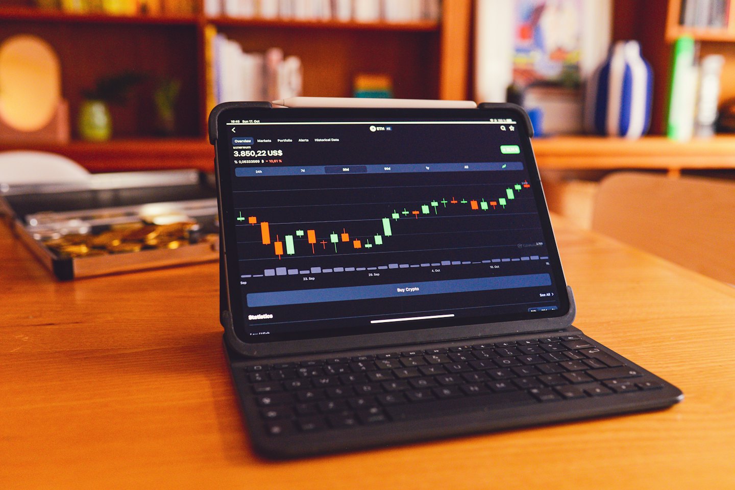 Tablet con grafico di criptovalute su una scrivania di legno.